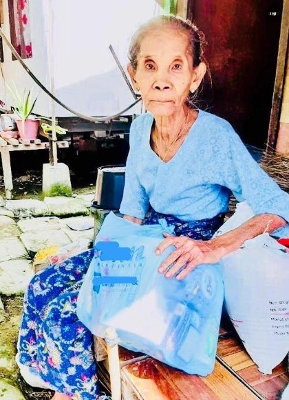 Elderly lady holding humanitarian relief kit