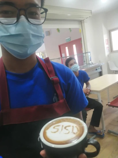 SISU trainee showing coffee art