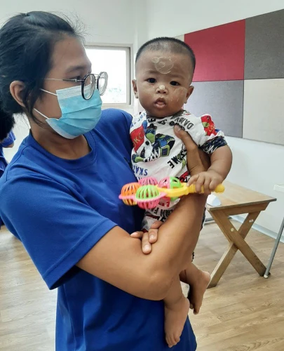 SISU trainee holding baby during practical class