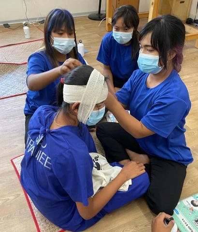 SISU first aid trainees learning bandaging
